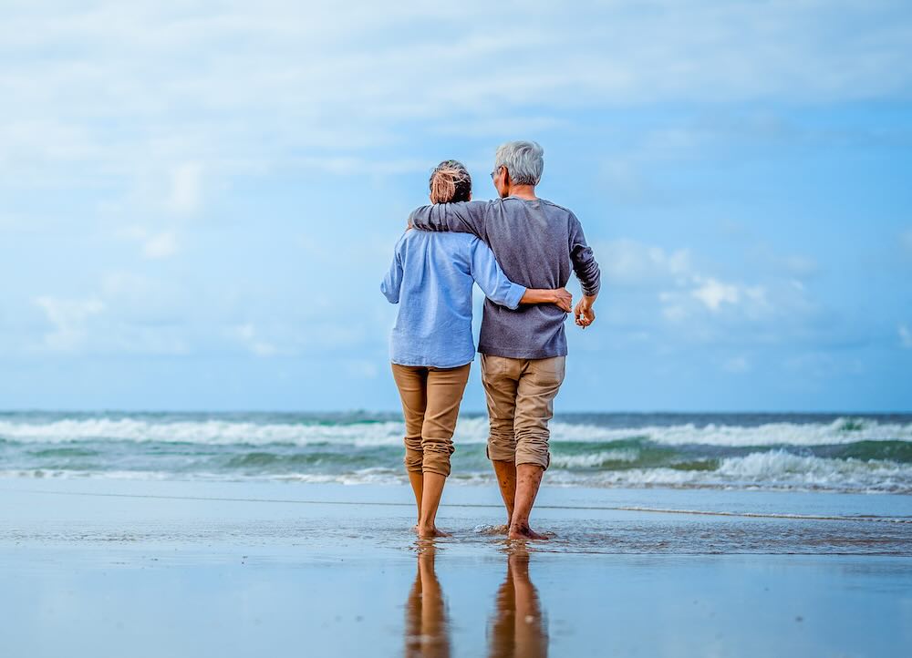 Senior couple walking on the beach holding hands at a beach